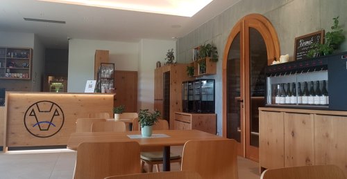 Interiéru dominuje dřevěný nábytek, automat je umístěný uprostřed zadní stěny interiér vinotéky
